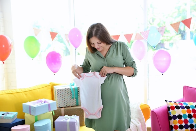 Zwangere vrouw met cadeautjes op baby shower feestje