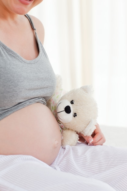 Zwangere vrouw met een knuffelig speeltje