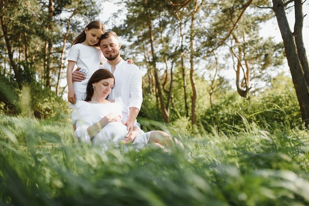 Zwangere vrouw met haar familie die er gelukkig uitziet