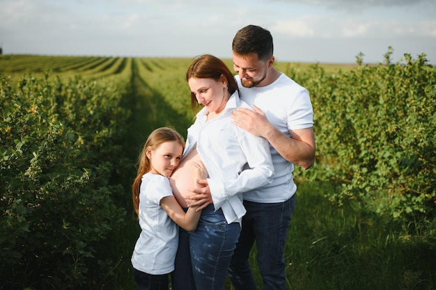 Zwangere vrouw met haar familie die er gelukkig uitziet
