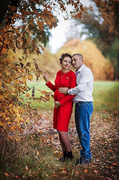 Zwangere vrouw met haar man in het herfstpark