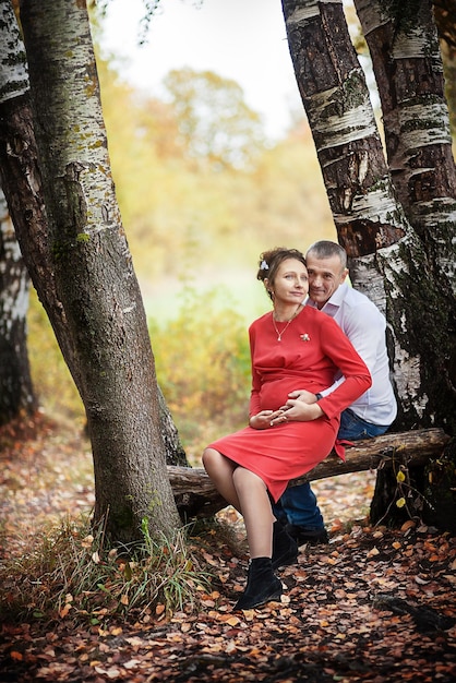 Zwangere vrouw met haar man in het herfstpark