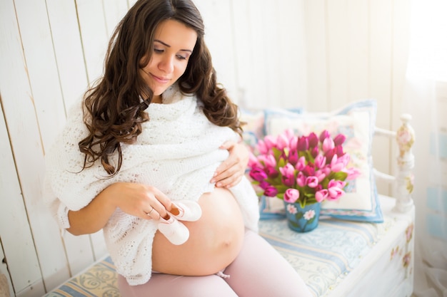 Zwangere vrouw met kleine schoenen voor de ongeboren