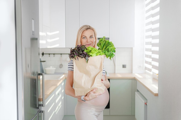 Zwangere vrouw met pakjes verse kruiden groene smoothies het concept van gezond en gezond voedsel voor zwangere vrouwen