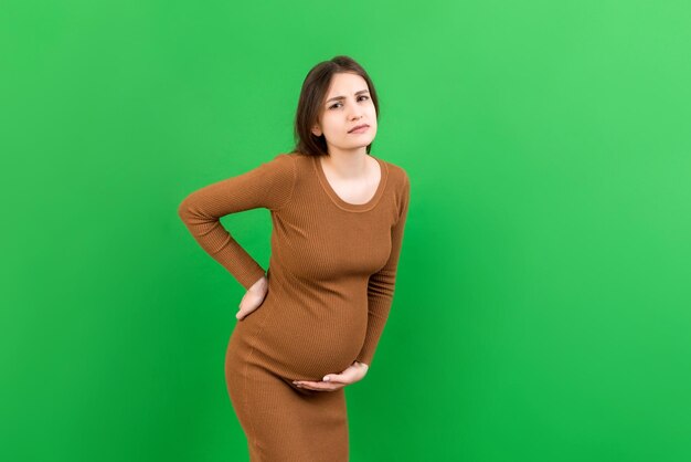Zwangere vrouw met rugpijn op gekleurde achtergrond geïsoleerd