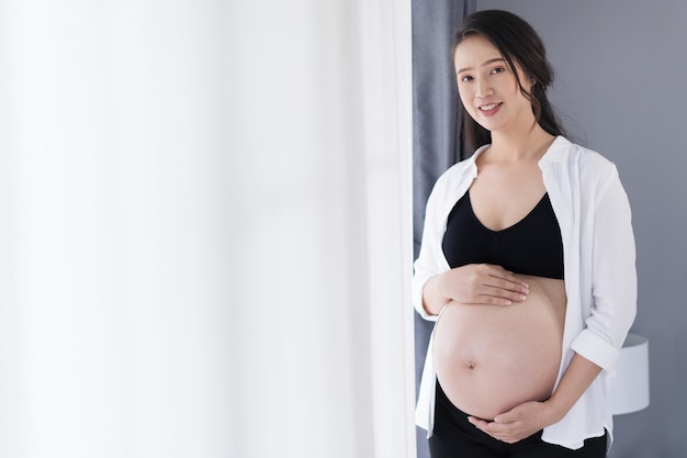 Zwangere vrouw met vensterachtergrond