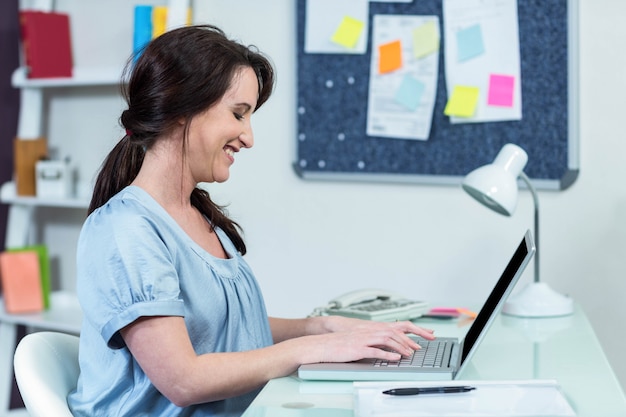 Zwangere vrouw op haar laptop thuis