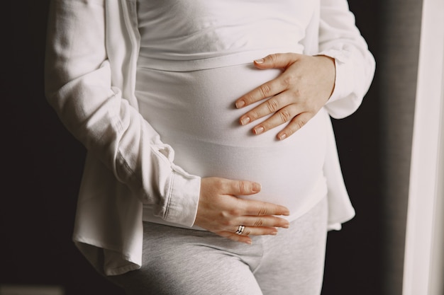 Zwangere vrouw permanent en haar buik aan te raken.
