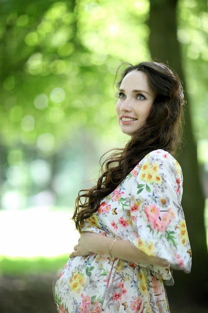 Zwangere vrouw poseren in het park