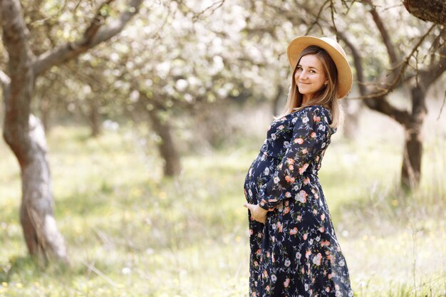 Zwangere vrouw tussen de bloemen