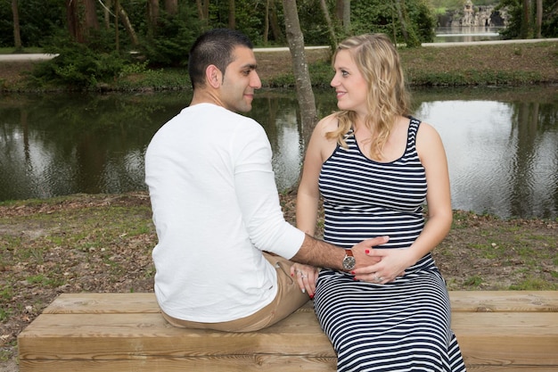 Zwangere vrouw vrouw met man man buiten rivierzijde aanraken buik