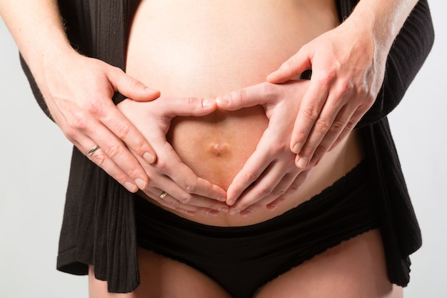 Zwangere vrouw wat betreft haar buik of babybuil