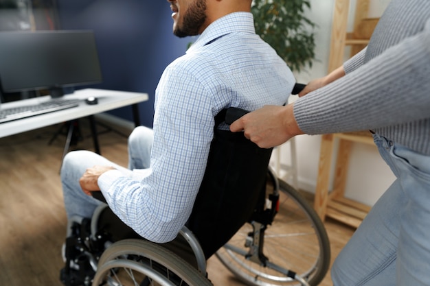 Zwangere vrouw zorgt voor haar gehandicapte man in rolstoel