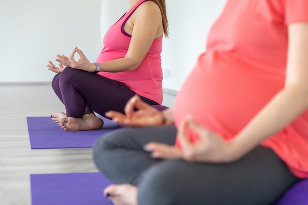 Zwangere vrouwen doen yoga en maditition in yogales, gezonde prenatale levensstijl