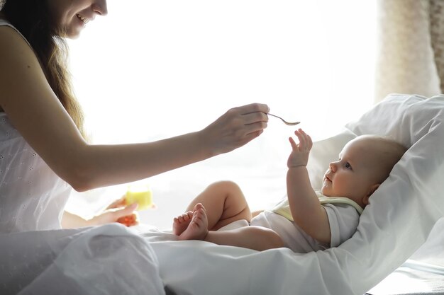 Zwangerschapsconcept. een jonge moeder voedt haar kleine baby. eerste lokken en borstvoeding. grote familie in witte kleren.