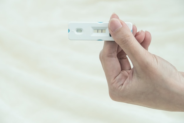 Zwangerschapstest met positieve zwanger in vrouwenhand