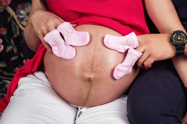 Foto zwangerschapsvingers lopen op een zwangere buik foto van de buik van een zwangere vrouw close-up van menselijke handen die de zwangere buik vasthouden zwangerschapsconcept