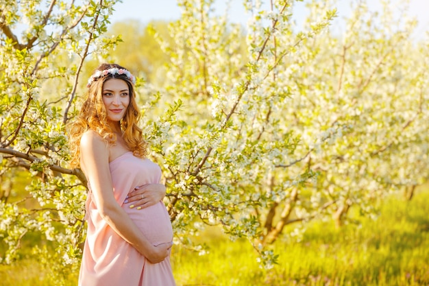 Zwangerschapsvrouw in de lente bloeiende tuin mooi zwanger meisje pregnant