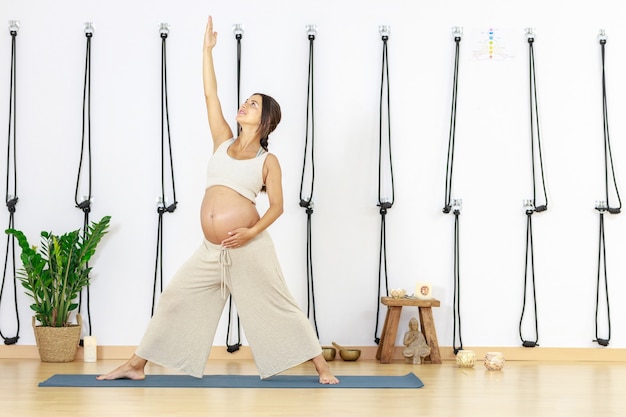 Zwangerschapsyoga jonge vrouw beoefent yoga thuis