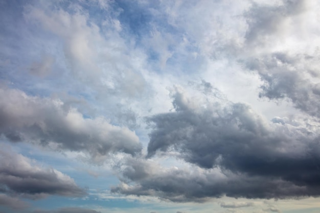 Zware donkere pluizige wolken op blauwe hemelachtergrond