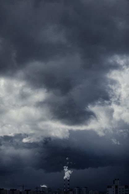 Zware donkere wolken bedekt gebouw. Er is luchtvervuiling onder de wolk.