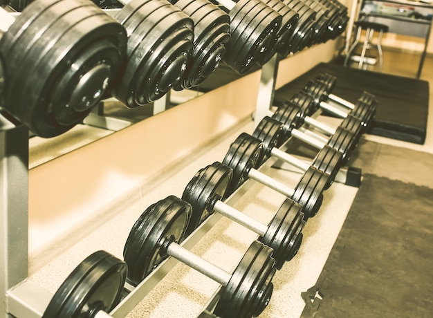 Zware halters die in de sportschool onbewerkt liggen. Fitness sport motivatie. Gelukkig gezond levensstijl leven. Oefeningen met staven gewichten.