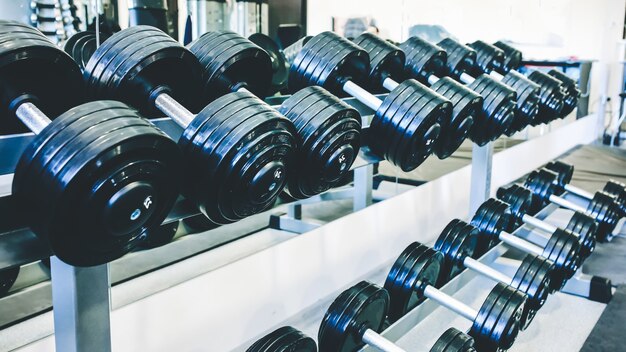 Zware halters die in de sportschool onbewerkt liggen. Fitness sport motivatie. Gelukkig gezond levensstijl leven. Oefeningen met staven gewichten.