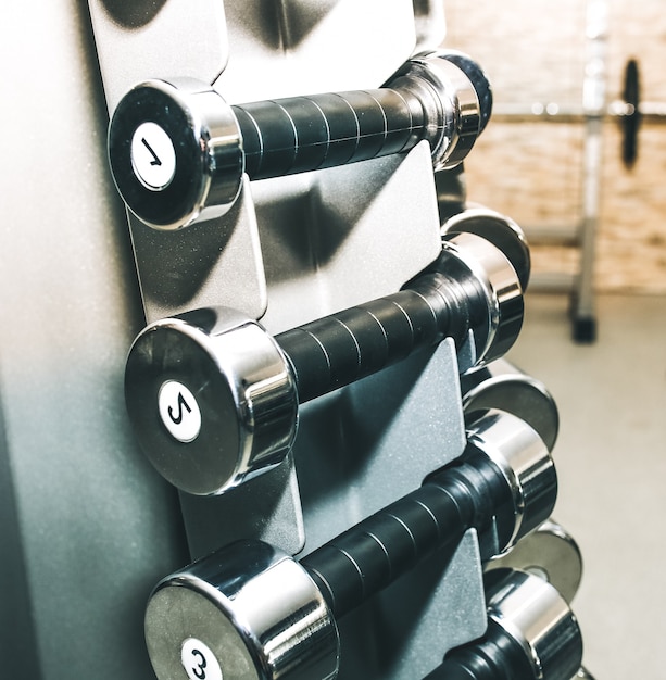 Zware halters die in de sportschool onbewerkt liggen. Fitness sport motivatie. Gelukkig gezond levensstijl leven. Oefeningen met staven gewichten.