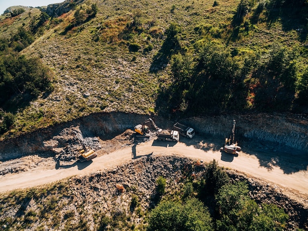 Zware machines werken bij het winnen van luchtfoto van rotsen