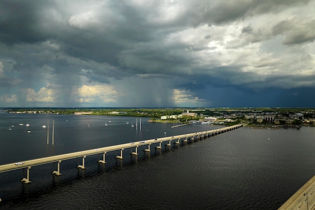 Foto zware onweersbuien naderen de verkeersbrug tussen punta gorda en port charlotte over de peace river slechte weersomstandigheden voor het rijden tijdens het regenseizoen in florida