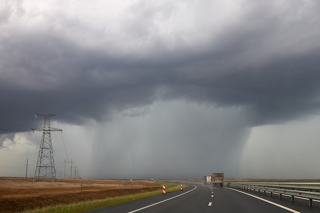 Zware regen valt uit een wolk die over de snelweg hangt