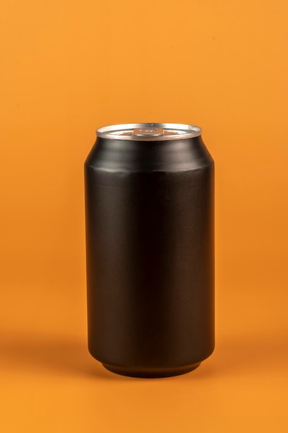 Zwart aluminium blikje geïsoleerd op oranje achtergrond