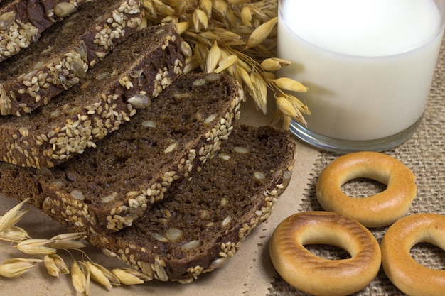 Zwart brood met sesamzaadjes en zonnebloempitten, haver, tarweoren, een glas melk