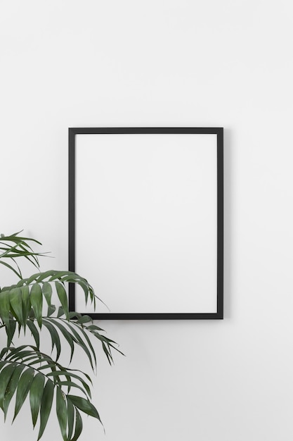 Foto zwart frame mockup aan de muur met een palmplant