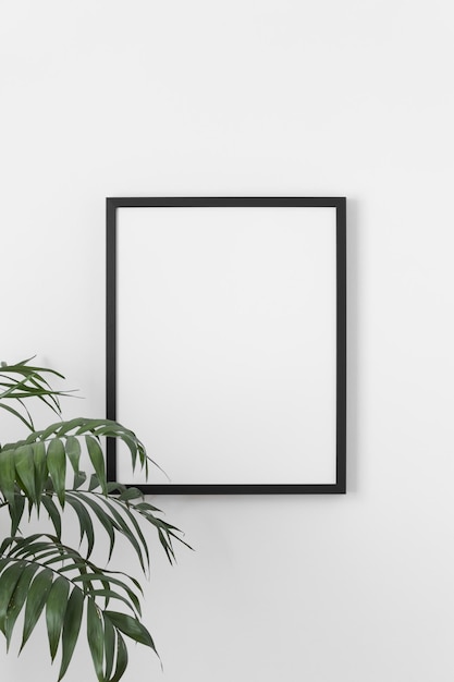 Zwart frame mockup aan de muur met een palmplant