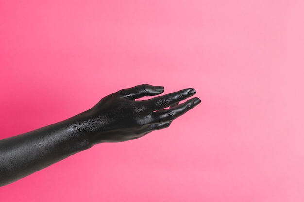 Zwart geschilderde elegante vrouwen hand op haar huid gesticuleert op roze achtergrond High Fashion kunstconcept