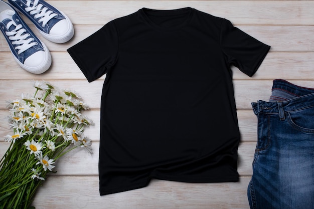 Zwart katoenen T-shirt mockup met wilde madeliefje bloemen boeket en jeans Ontwerp t-shirt sjabloon tee print presentatie mock up