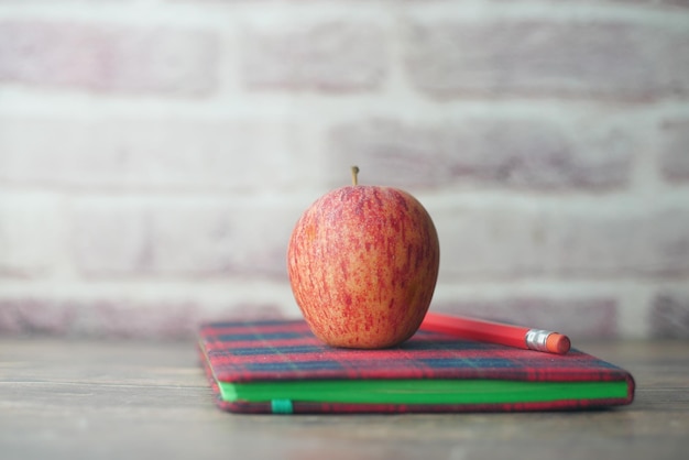 Zwart naar school concept met appel op kladblok op tafel