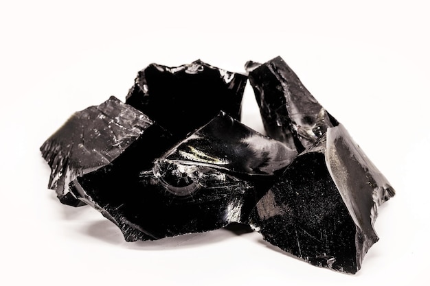 Zwart Obsidiaan zwart en kristallijn erts op geïsoleerde witte achtergrond Zwart gekleurde steen therapeutische gebruikt in meditatie