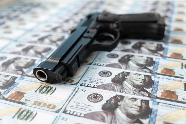Zwart pistool op de achtergrond van contant geld dollars concept van crimineel geld of moord voor geld bankoverval