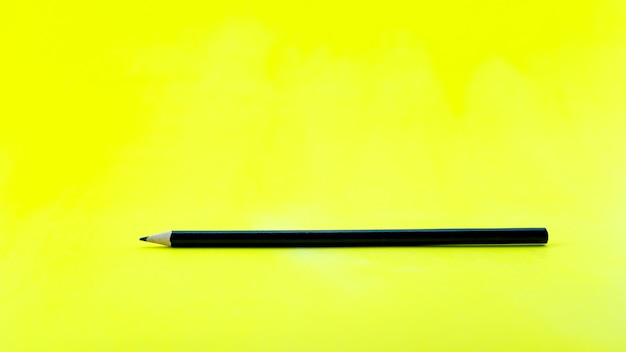 Zwart potlood op gele papieren achtergrond.