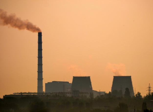 Zwart silhouet van fabriek bij zonsondergang dageraad