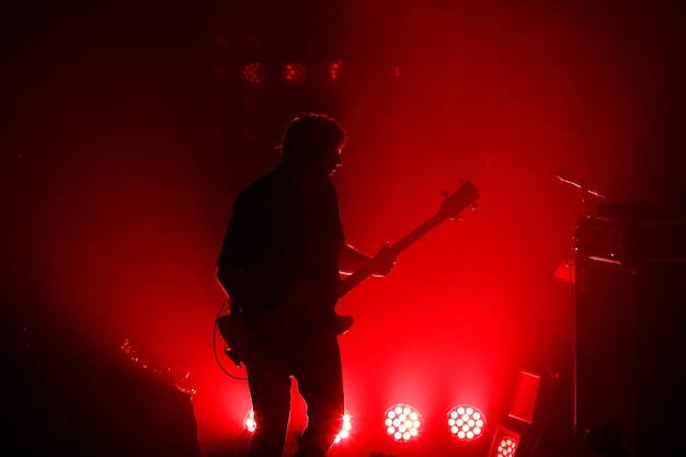 Zwart silhouet van gitarist bij rockconcert