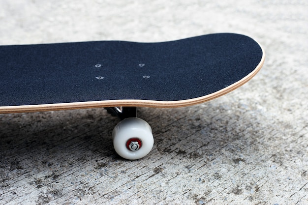 Zwart skateboard op cementgrond