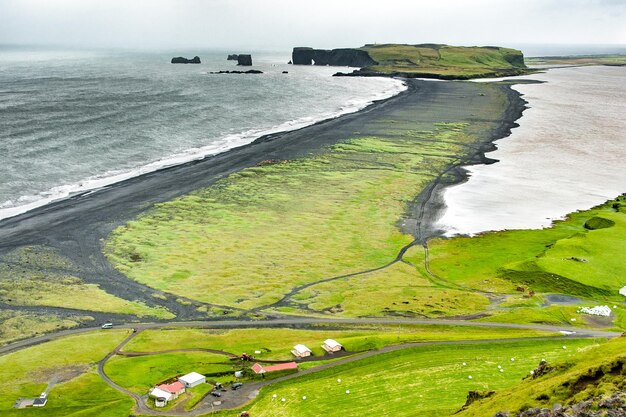 Zwart strand, grijze lucht en ruwe zee in de regio Vik, IJsland