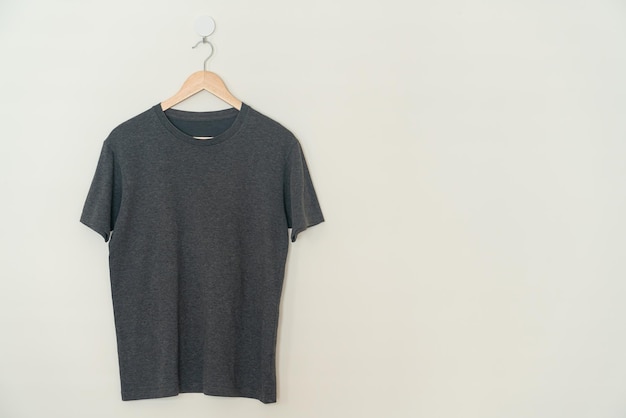 zwart t-shirt hangend met houten hanger aan de muur