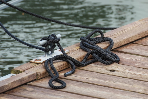 Zwart touw op houten brug als onderdeel van jachtanker Detail van zeilboot Transport