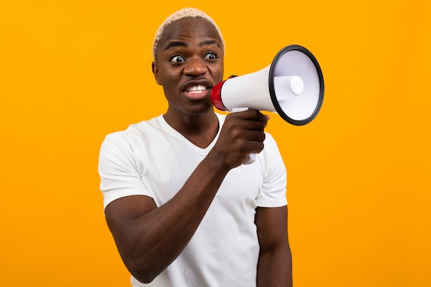 Zwart verrast Amerikaanse man in wit t-shirt vertelt het nieuws via een megafoon op geïsoleerde oranje