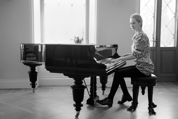 Zwart-wit beeld pianist dame speelt fortepiano voor het raam vrouwen gelijkheid concept