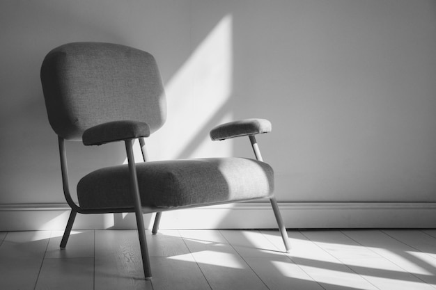 Zwart-wit beeld van een stijlvolle fauteuil in de binnenlandse kamer met zonlicht uit het raam Huissamenstelling van een gezellige woonkamer